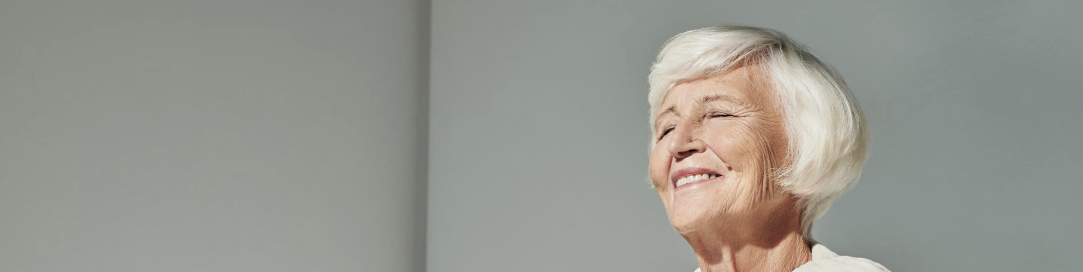 Mujer mayor sonriendo con los ojos cerrados